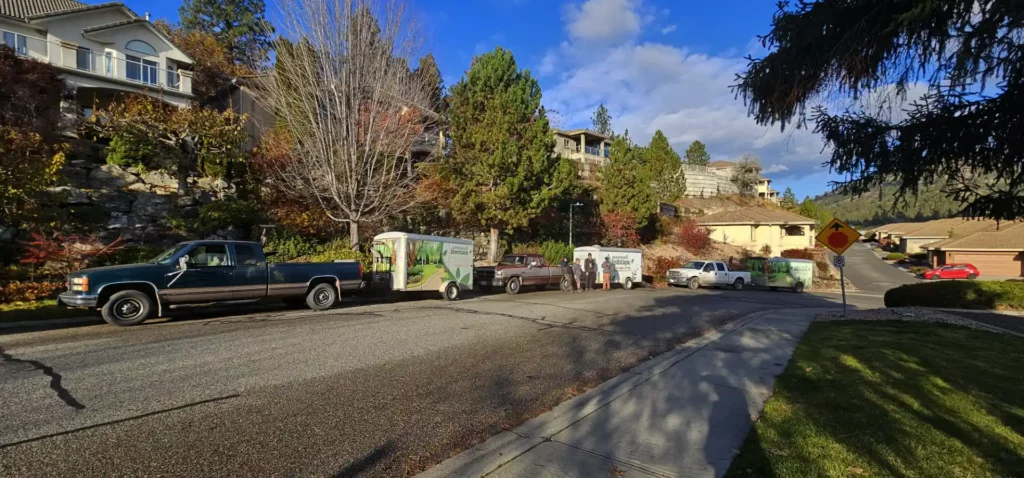 The Greenpath Landscape Maintenance Crew with their trucks and trailers in front of a Kelowna residential property